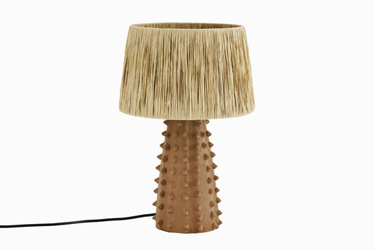 Lámpara de terracota con pantalla de paja.