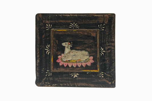 A painted panel picture of a holy cow on a lily pad