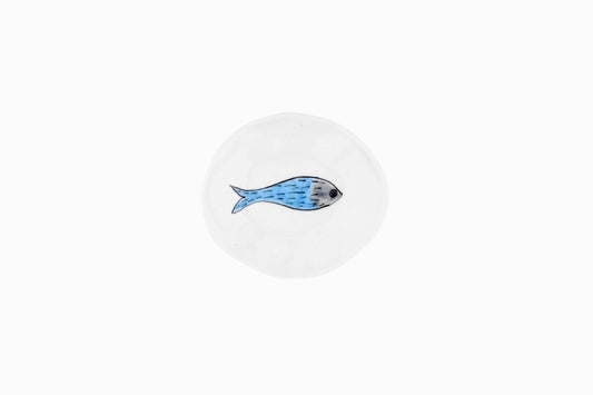 Pequeño plato de porcelana con un pez azul nadando a la derecha