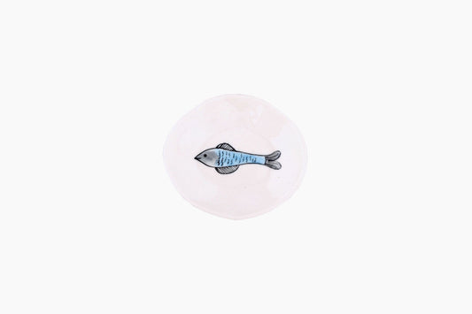 Tiny porcelain dish with blue fish swimming to the left